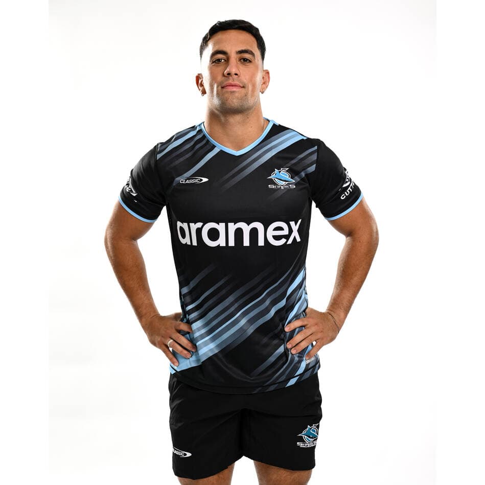 Maglia da allenamento per bambini dei Cronulla Sharks: maglia da rugby nera e azzurra con logo dello sponsor Aramex.