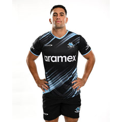 Maglia da allenamento per bambini dei Cronulla Sharks: maglia da rugby nera e azzurra con logo dello sponsor Aramex.