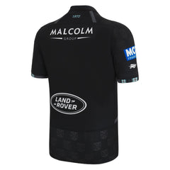 Maglia da rugby casalinga dei Glasgow Warriors Youth 2023: maglia nera con stemma della squadra e loghi degli sponsor.