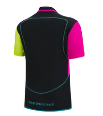 Maglia da allenamento da rugby per bambini dei Glasgow Warriors 2023: design nero, rosa fluo e giallo. Scritta "Whatever it takes" sul retro.