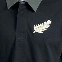 Polo Rugby All Blacks Vintage 1938: maglietta da rugby nera con una felce argentata ricamata.