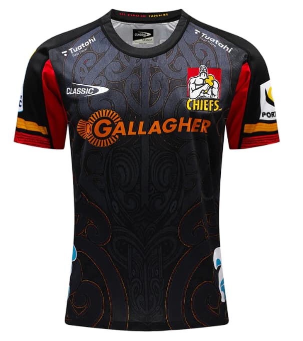 Maglia da rugby Chiefs Super Rugby Pacific Home 2024-25: maglia da rugby nera per ragazzi con design Maori, dettagli arancioni e rossi.