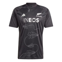 T-shirt Adidas All Blacks Rugby Performance 2024: maglia da rugby nera con motivo a felce e logo dello sponsor INEOS.