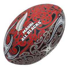 Pallone Rugby All Blacks Maori Supporter 2026: pallone da rugby ufficiale con design Maori All Blacks e motivi tradizionali in rosso e grigio.