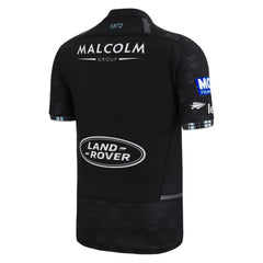 Maglia da rugby autentica Glasgow Warriors 2023 Home: maglia nera con loghi Land Rover e Malcolm Group, caratterizzata da un motivo discreto e dettagli azzurri.