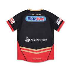 Maglia alternativa NRL dei Redcliffe Dolphins: maglia da rugby nera con dettagli rossi e oro, con loghi BlueBet e AngloAmerican. Abbigliamento della squadra per i tifosi della NRL.