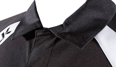 Polo sportiva nera da allenamento, dettaglio colletto e inserti bianchi.