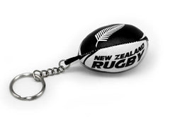 Portachiavi a forma di pallone da rugby nero e bianco, con logo "New Zealand Rugby" e foglia di felce.