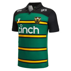 Maglia da rugby casalinga Northampton Saints 2023: maglia da professionista verde con maniche nere e strisce dorate, con logo della squadra e sponsor.