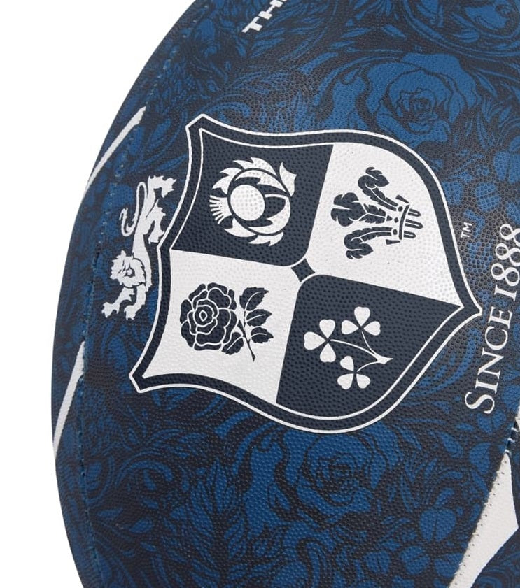 Pallone Rugby British & Irish Lions Thrillseeker Blu: pallone da rugby blu navy con stemma raffigurante le quattro nazioni di appartenenza e un motivo a rosa.