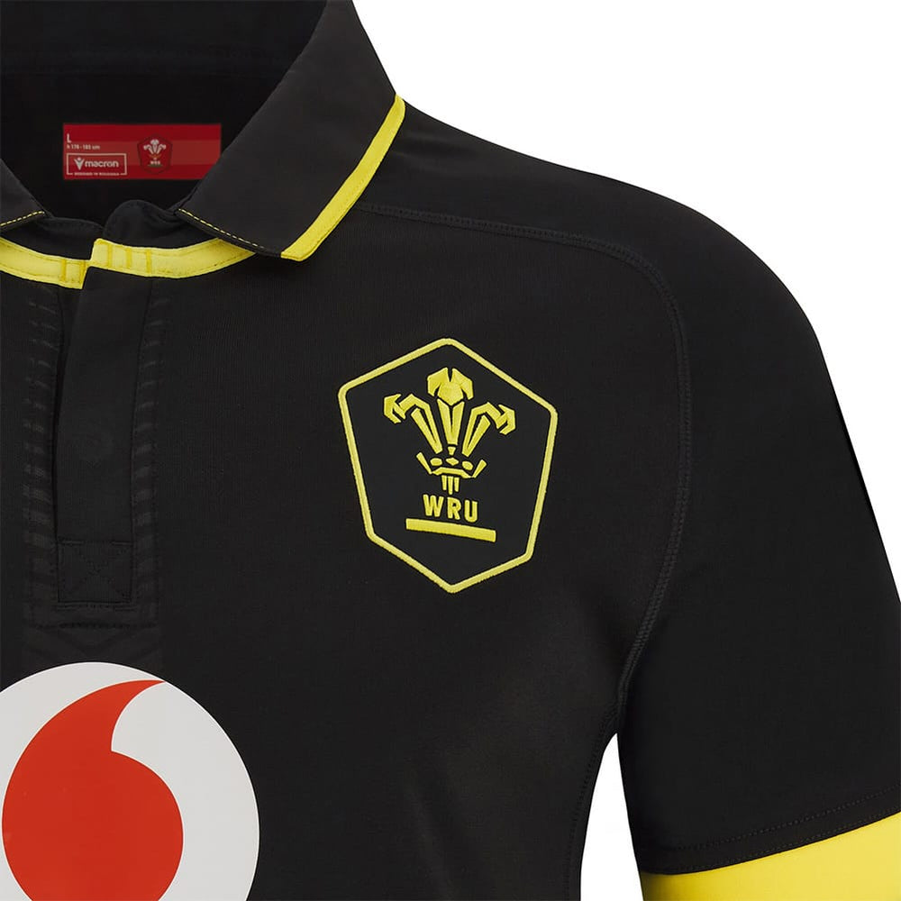 Maglia rugby Galles Macron M24 Away nera con stemma WRU giallo.