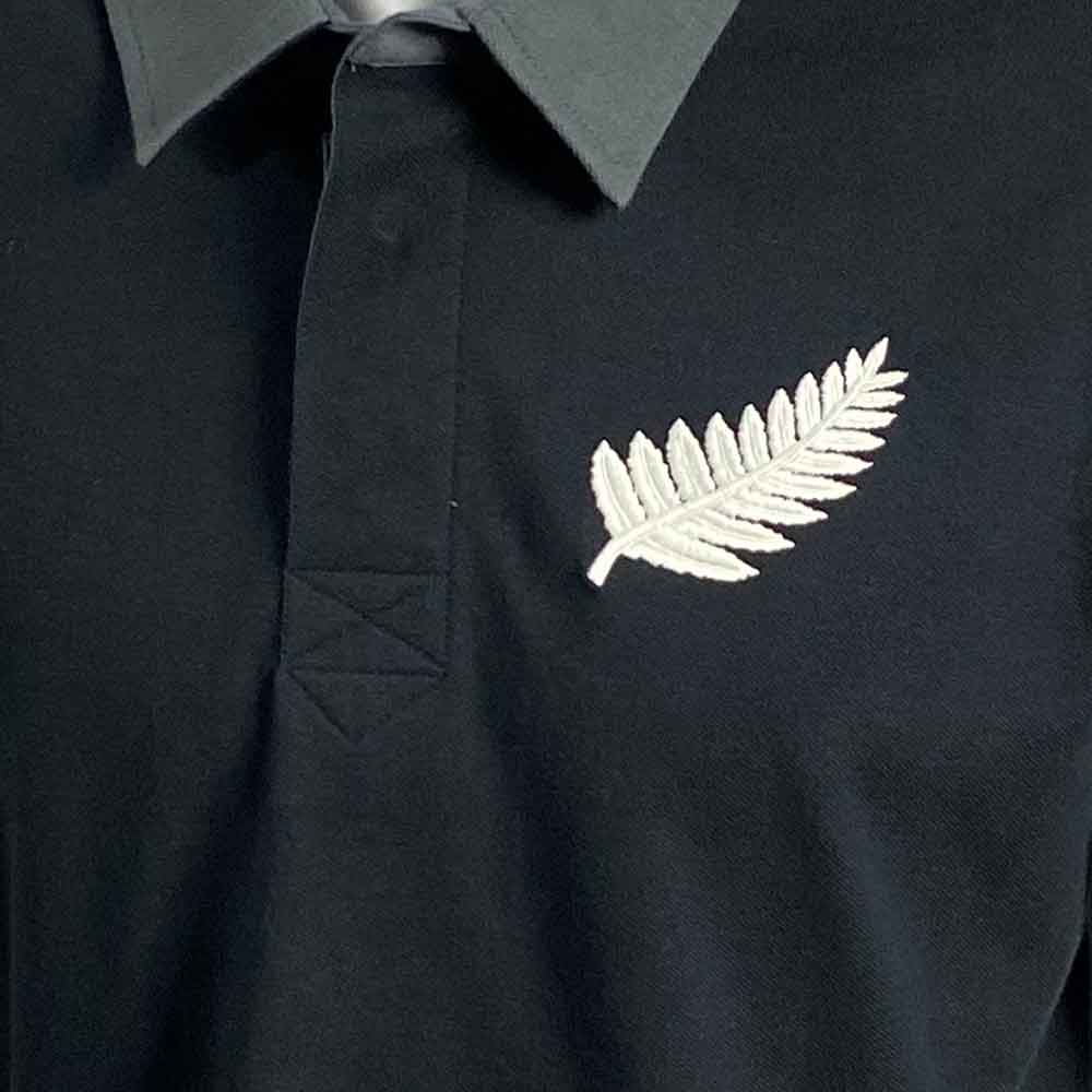 Polo Rugby All Blacks Vintage 1938: maglietta da rugby nera con una felce argentata ricamata.