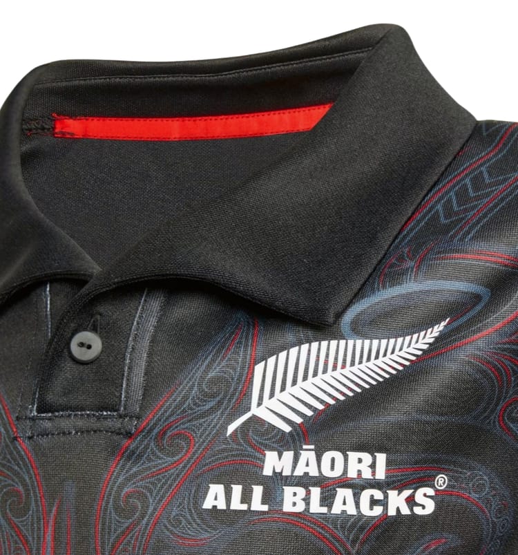 Maglia rugby All Blacks Maori ragazzo nera con felce bianca e dettagli rossi.