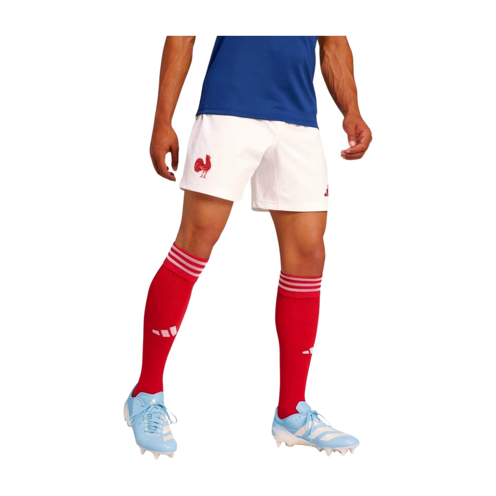 Pantaloncini da rugby ufficiali Adidas France: pantaloncini da rugby bianchi con l'emblema del gallo francese, indossati con calzini rossi e scarpe da calcio celesti.