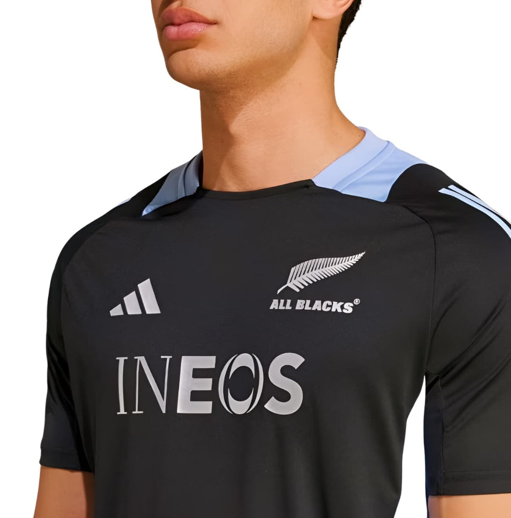 T-shirt Adidas All Blacks Rugby Performance 2025: maglia da rugby nera con dettagli azzurri, caratterizzata dall'iconica felce degli All Blacks e dal logo INEOS.