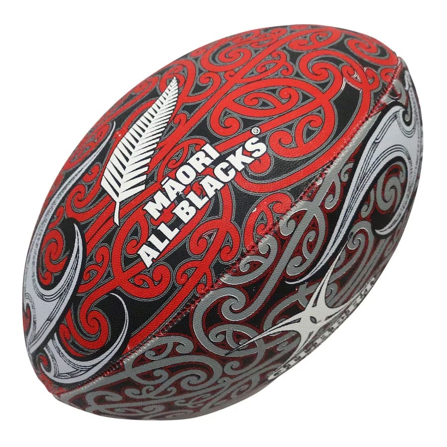 Pallone Rugby All Blacks Maori Supporter 2026: pallone da rugby ufficiale con design Maori All Blacks e motivi tradizionali in rosso e grigio.