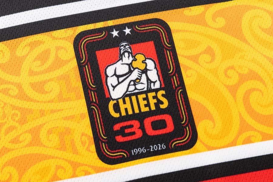 Dettaglio maglia rugby Chiefs 30 anni: logo celebrativo con guerriero e scudo.