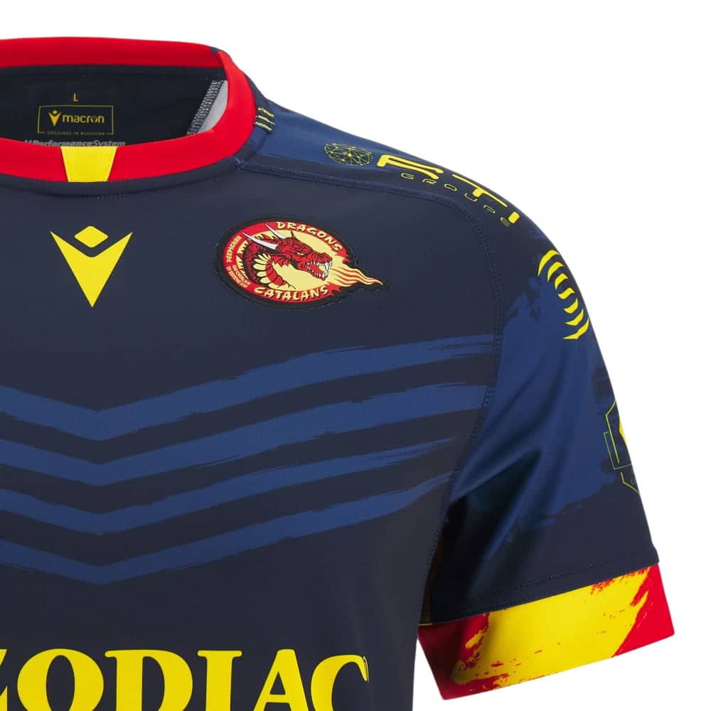 Maglia da rugby da trasferta dei Catalans Dragons 2023-24: blu navy con dettagli gialli e rossi, con il logo della squadra.