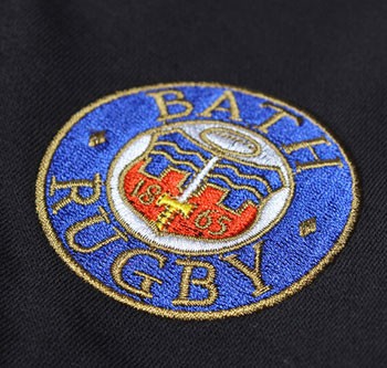 Pantaloncino ufficiale Bath Rugby con stemma ricamato blu e oro.