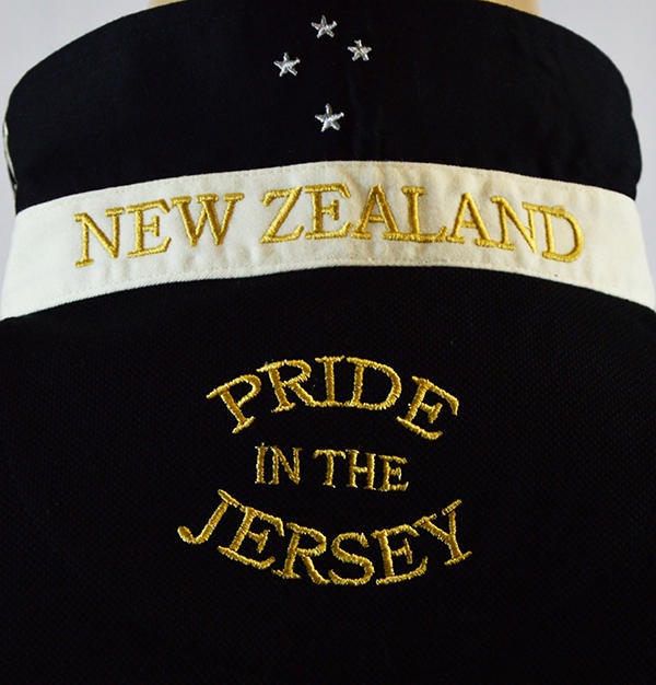 Polo rugby Nuova Zelanda nera con ricamo "New Zealand" e "Pride in the Jersey".