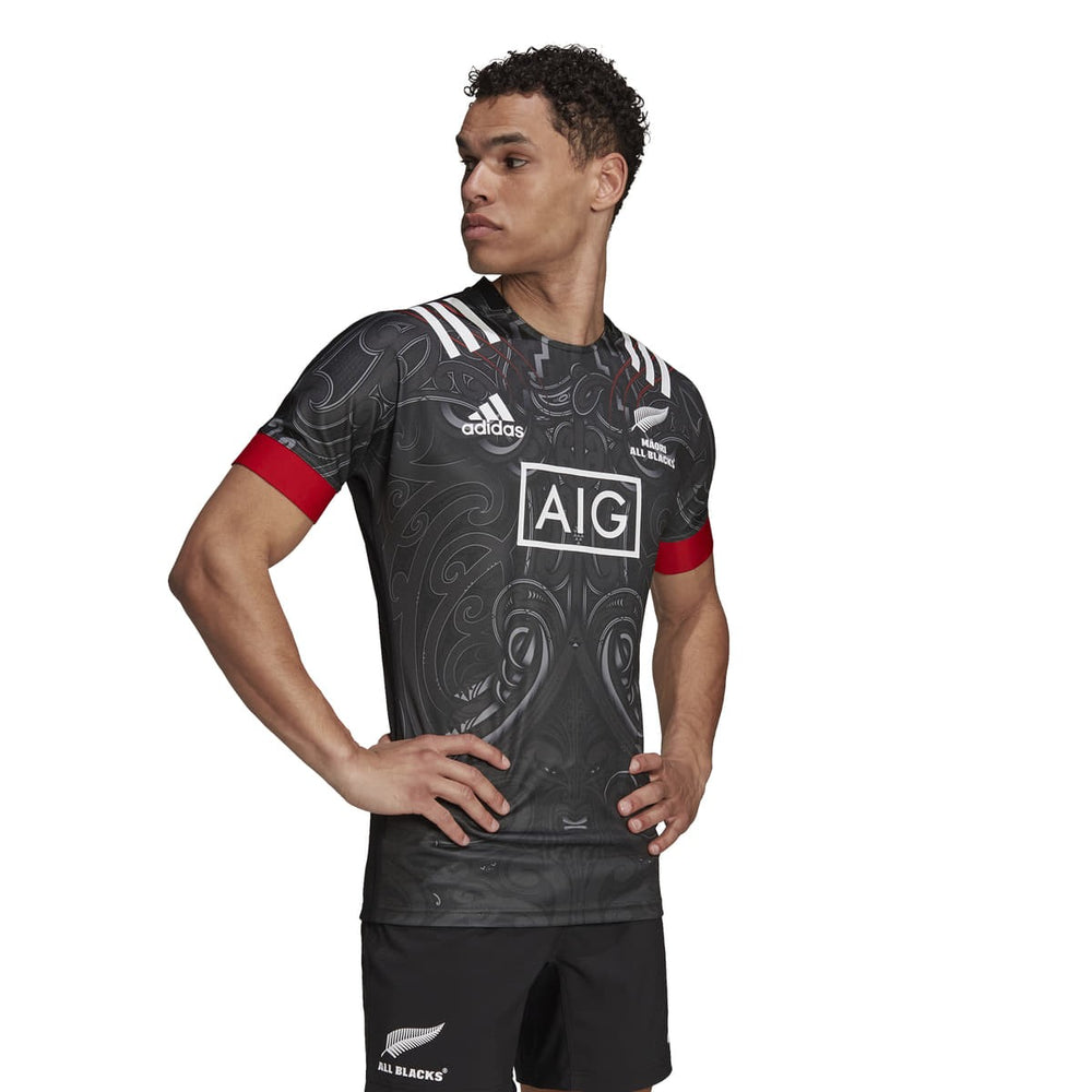 Maglia da rugby All Blacks Maori 2022 Adidas, nera con dettagli in rosso e grafiche tribali.