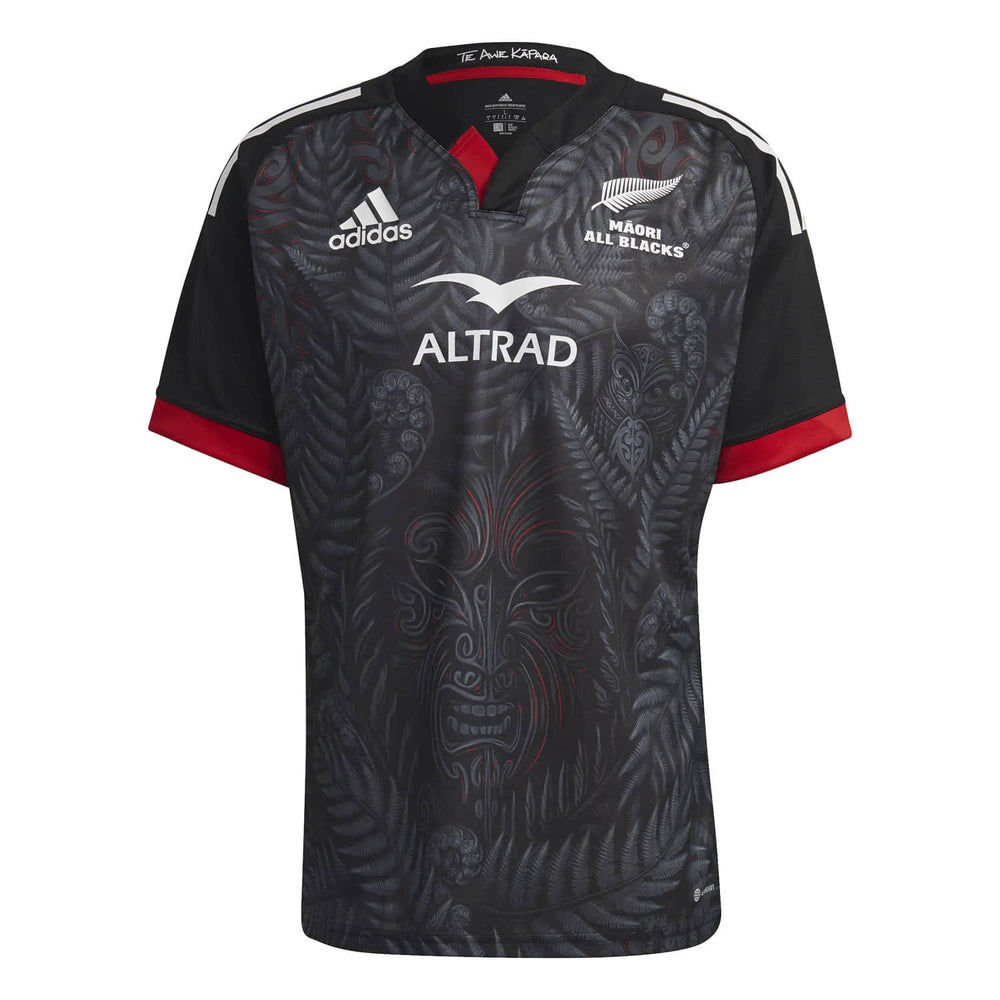 Maglia da rugby Māori All Blacks 2023-24: maglia Adidas nera con logo Maori All Blacks e intricato disegno di felci e tribù.